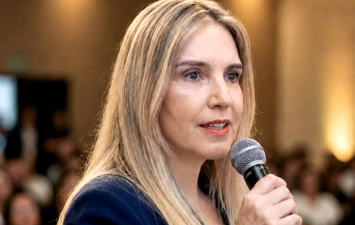 Andréa Boggio falando ao microfone em palestra